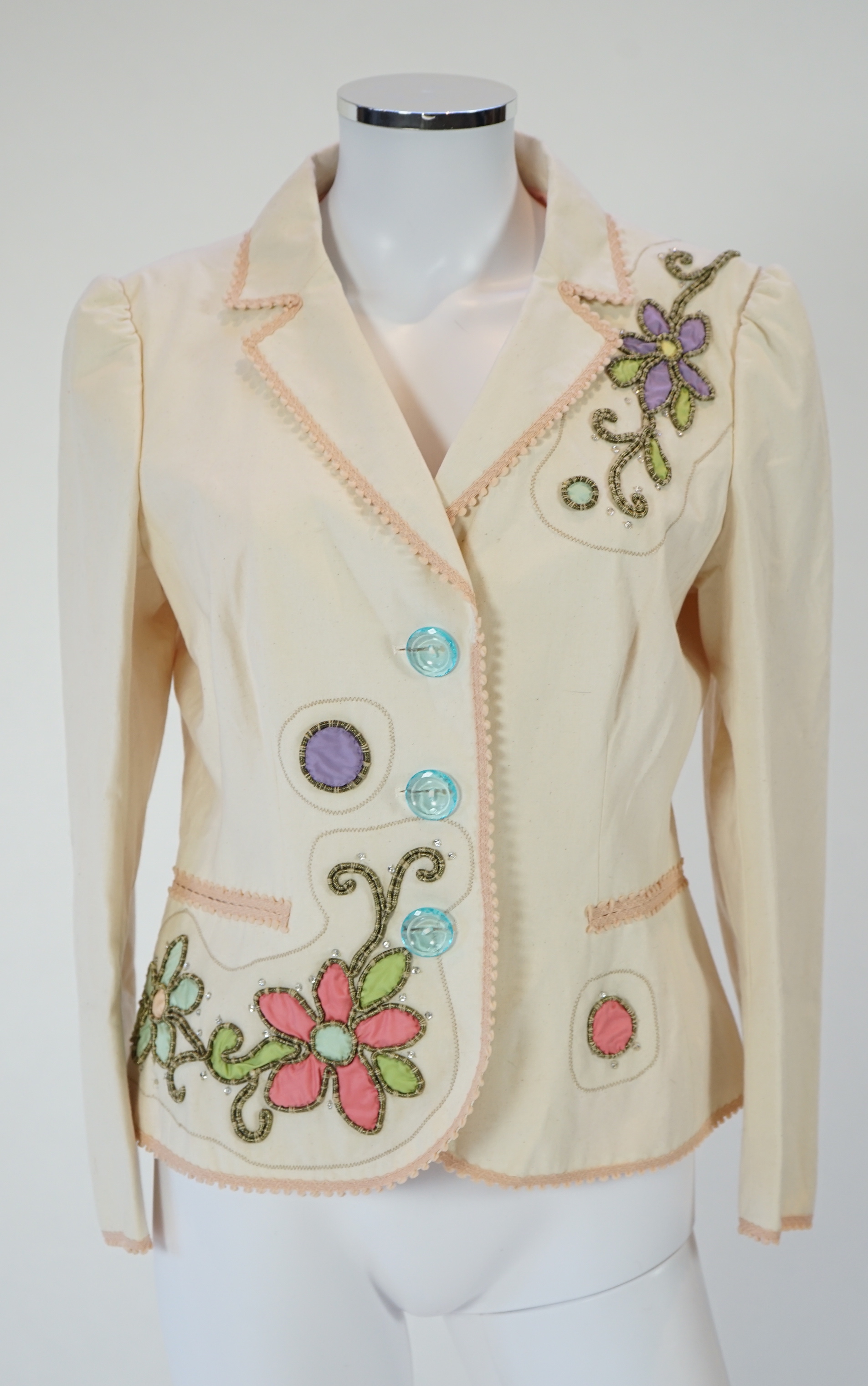 A Moschino lady's long blue and red jacket, a cream cotton embellished blazer and a cotton pair of floral trousers, blue and red jacket size 14, cream blazer size 12, trousers size: 10